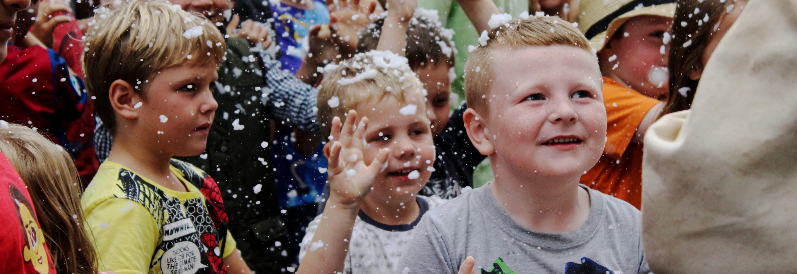 Group of boys in crowd playing with foam